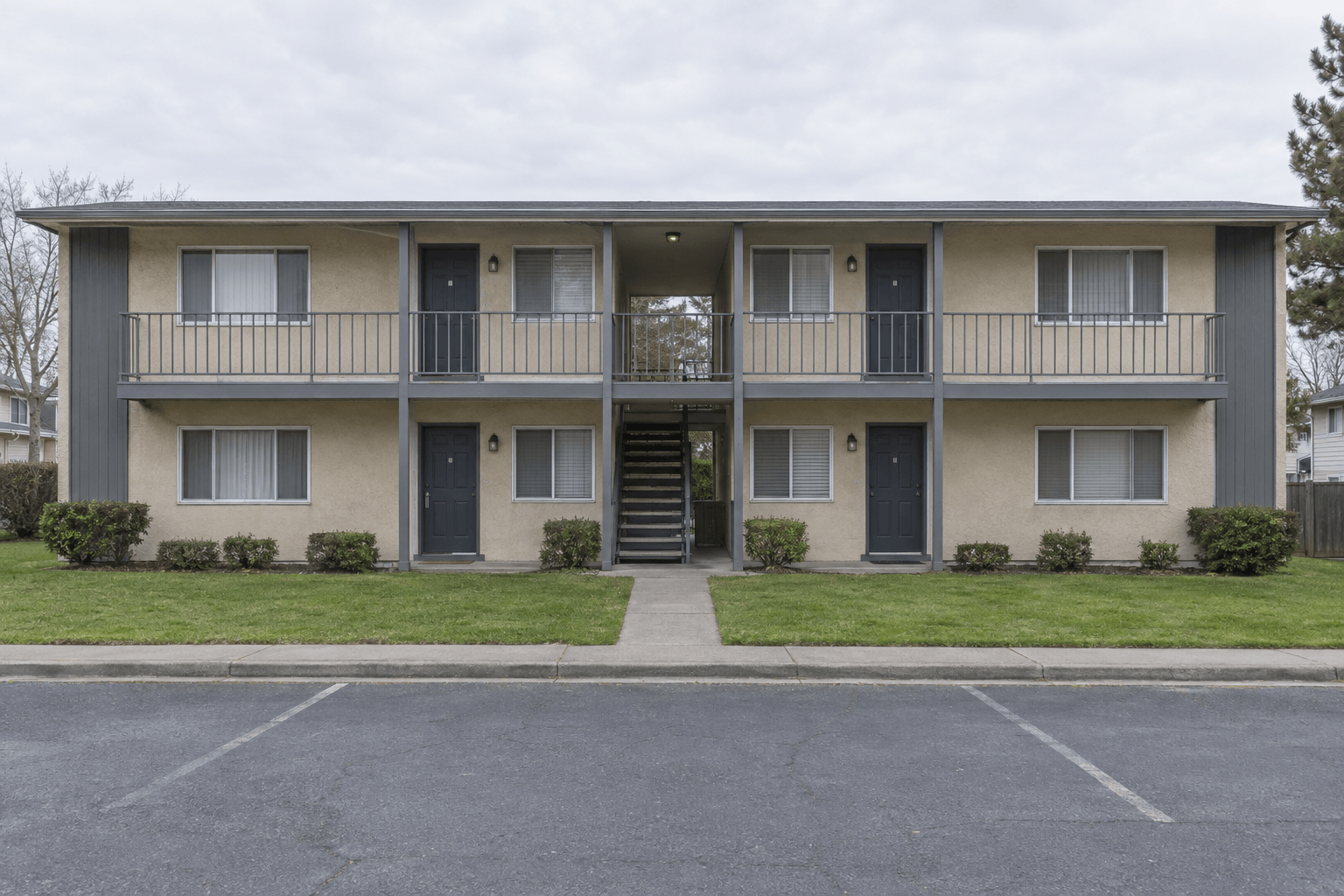 A two-storey eight-unit garden-style apartment building with exterior walkways.